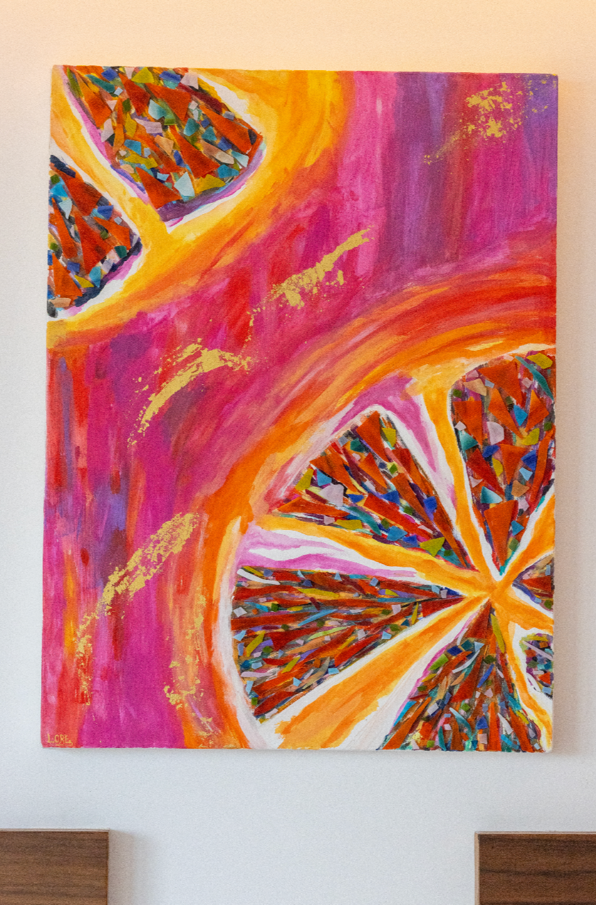 Cuadro abstracto con colores vibrantes y patrones geométricos en tonos rosados, anaranjados y dorados.