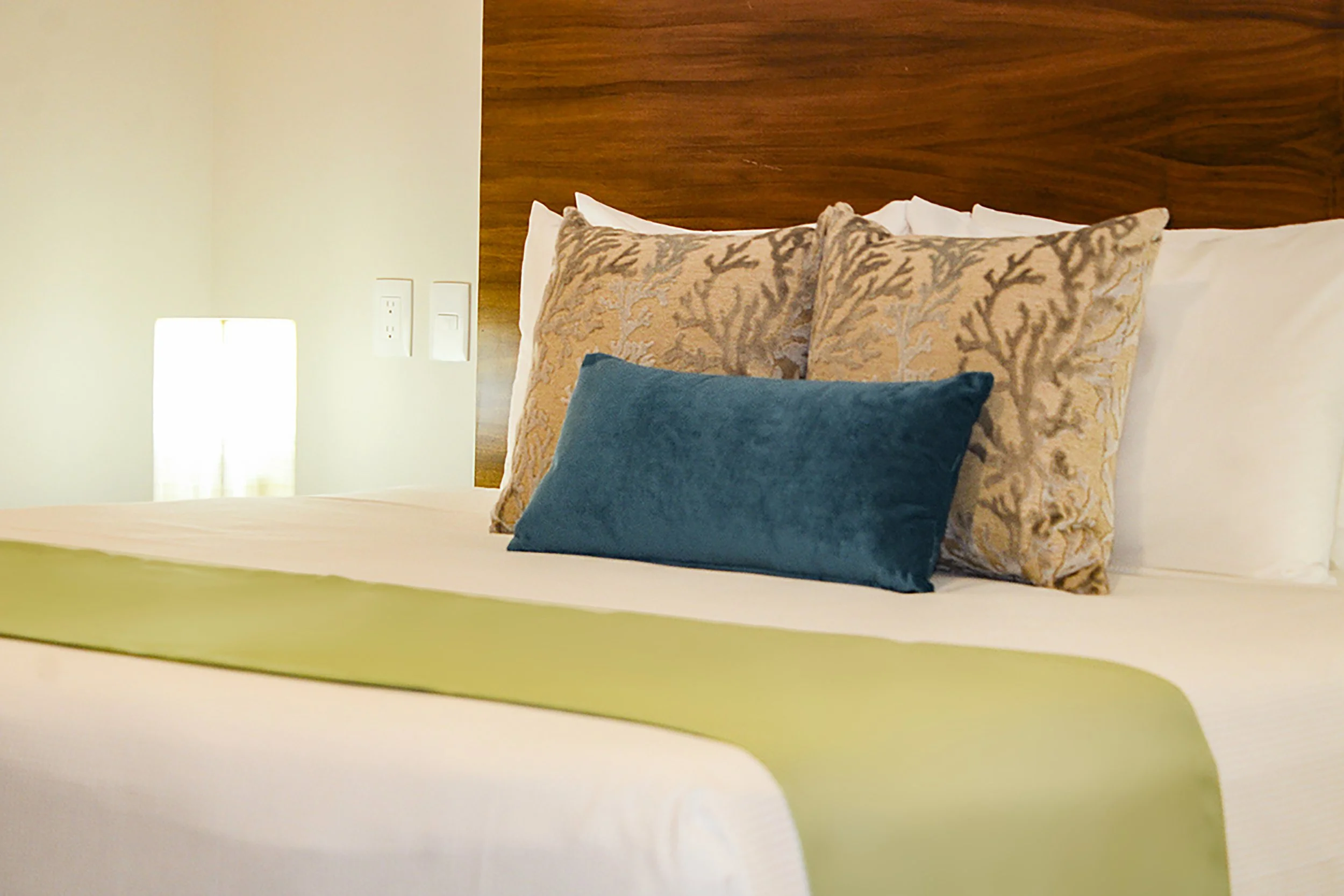 Cama con almohadas y cabecera de madera en una habitación
