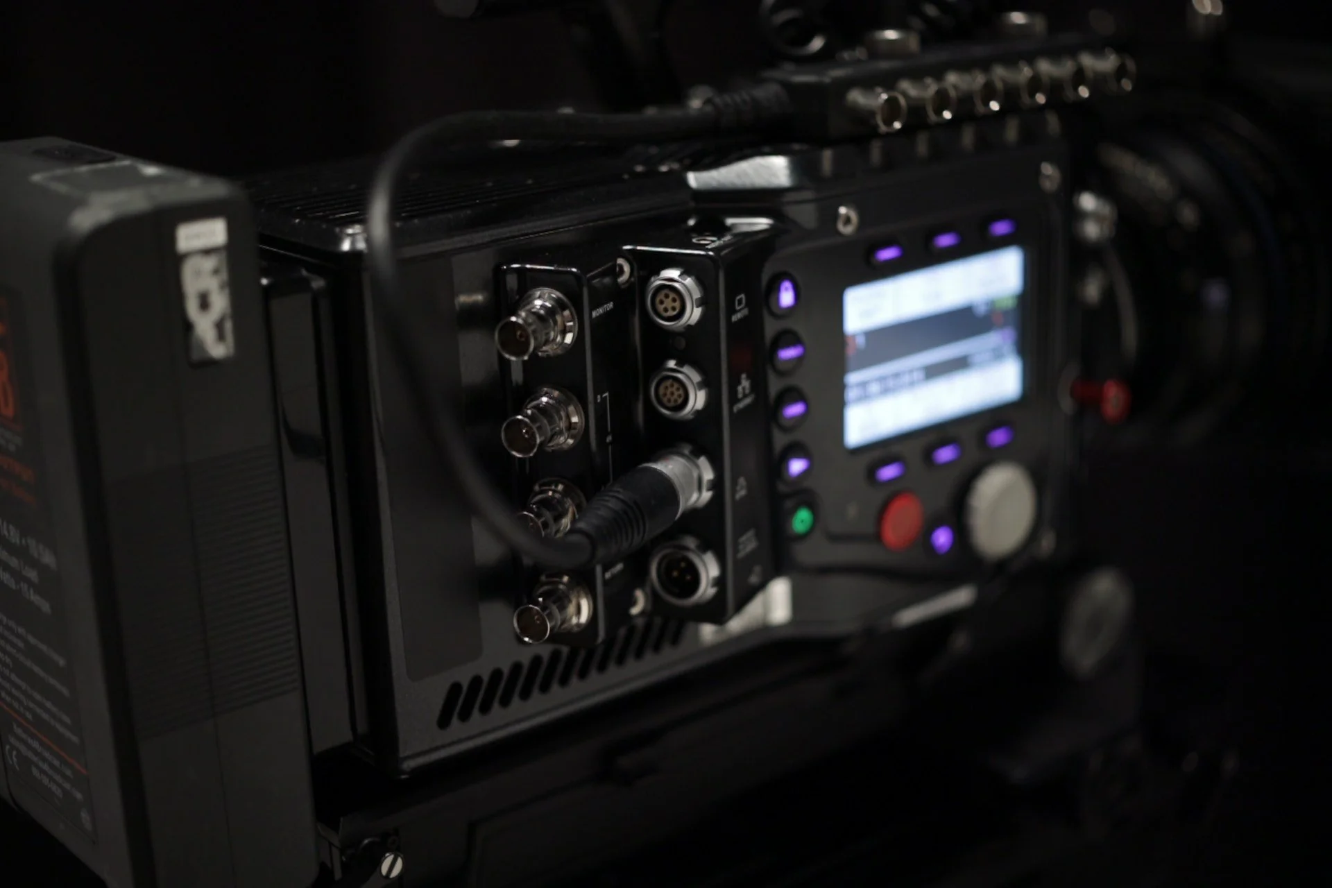 Close-up of a professional camera equipment showing various ports, connectors, and a digital display.
