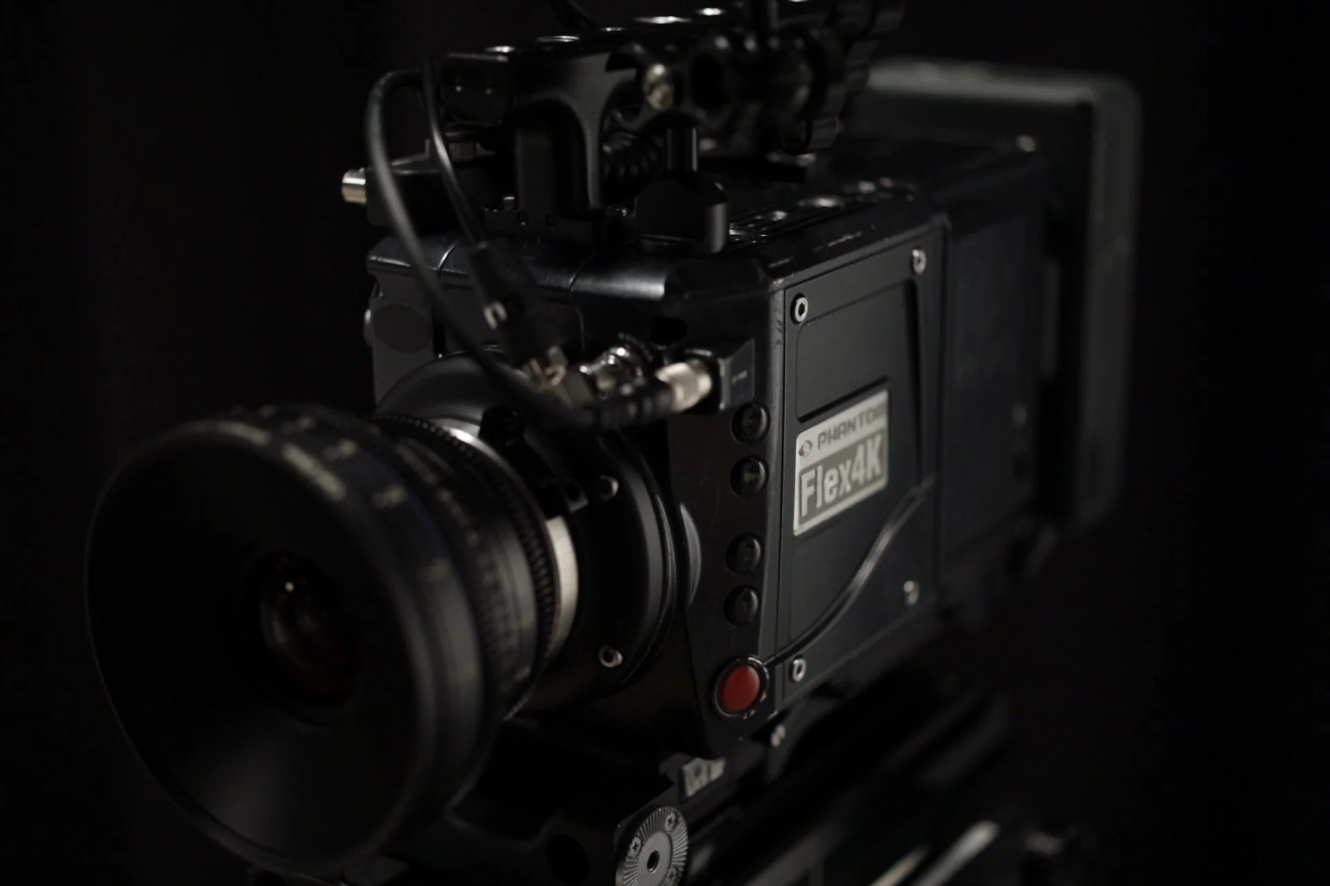 Close-up of a professional cinema camera with a matte black background.