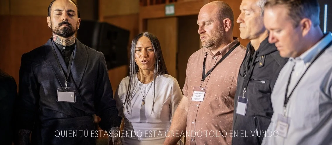 Grupo de personas de diferentes etnias en oración o meditación en un entorno interior, con mirada hacia arriba y con semblante pensativo o reflexivo.