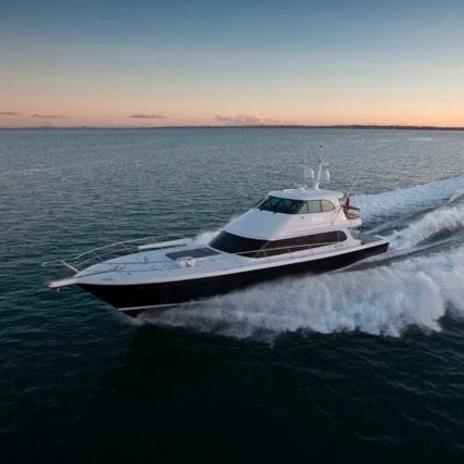 Motor yacht sailing on open water during sunset.