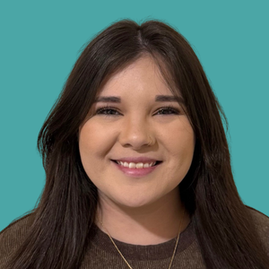 Close-up of a young woman with long dark hair smiling against a teal background.