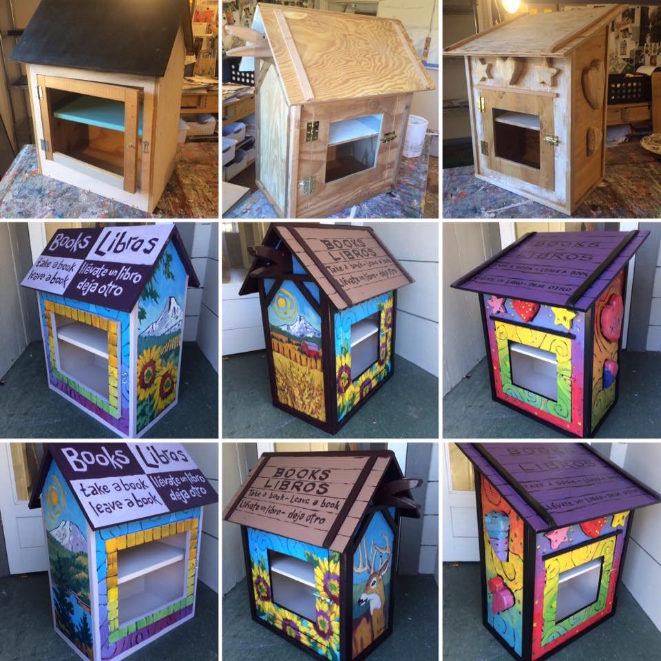 Six painted wooden book-sharing boxes, three unpainted and three decorated with colorful, nature-themed designs.