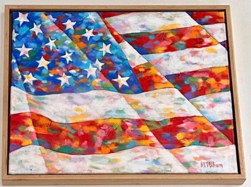 Colorful painting of the American flag in an artistic style displayed on a gallery wall.