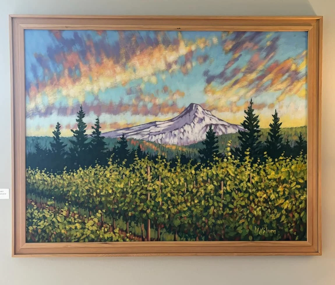 A landscape painting of Mount Hood with a colorful sky, evergreen trees, and green foliage in the foreground, signed by M. Nilsson. Mark Nilsson ©