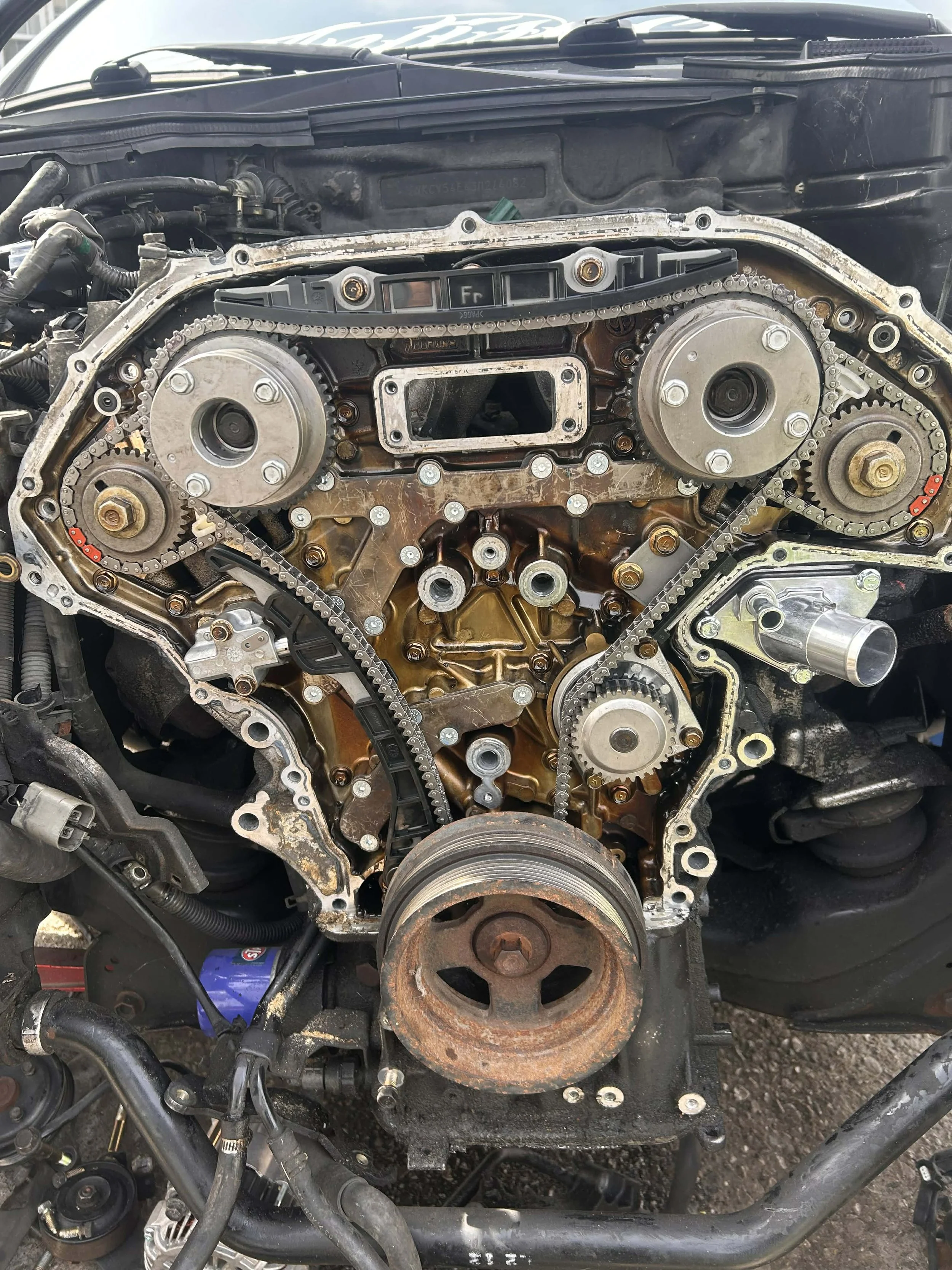 Engine with timing chain cover removed, exposing timing gears, chain, and internal components.