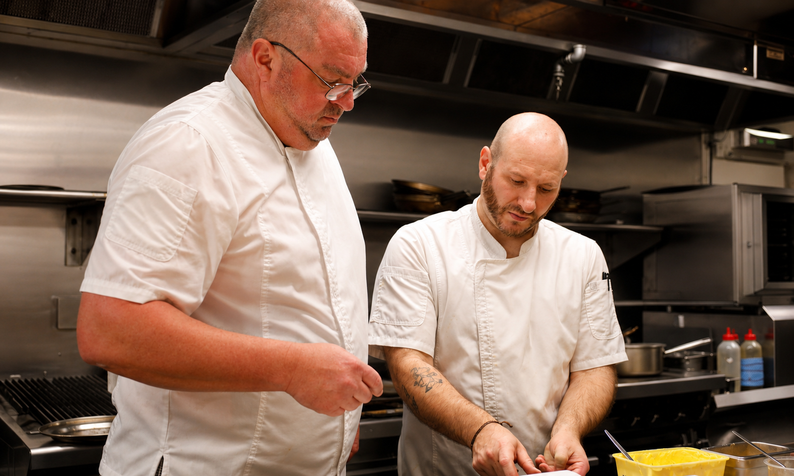 Two chefs preparing ingredients together in a commercial kitchen during a South Wharf Restaurants food event.