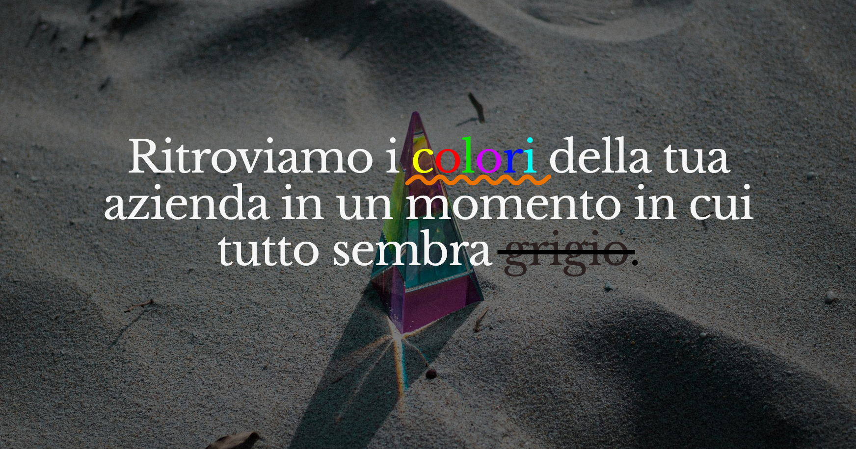 Sabbia con un prisma colorato con testo che dice: "Ritroviamo i colori della tua azienda in un momento in cui tutto sembra grigio".