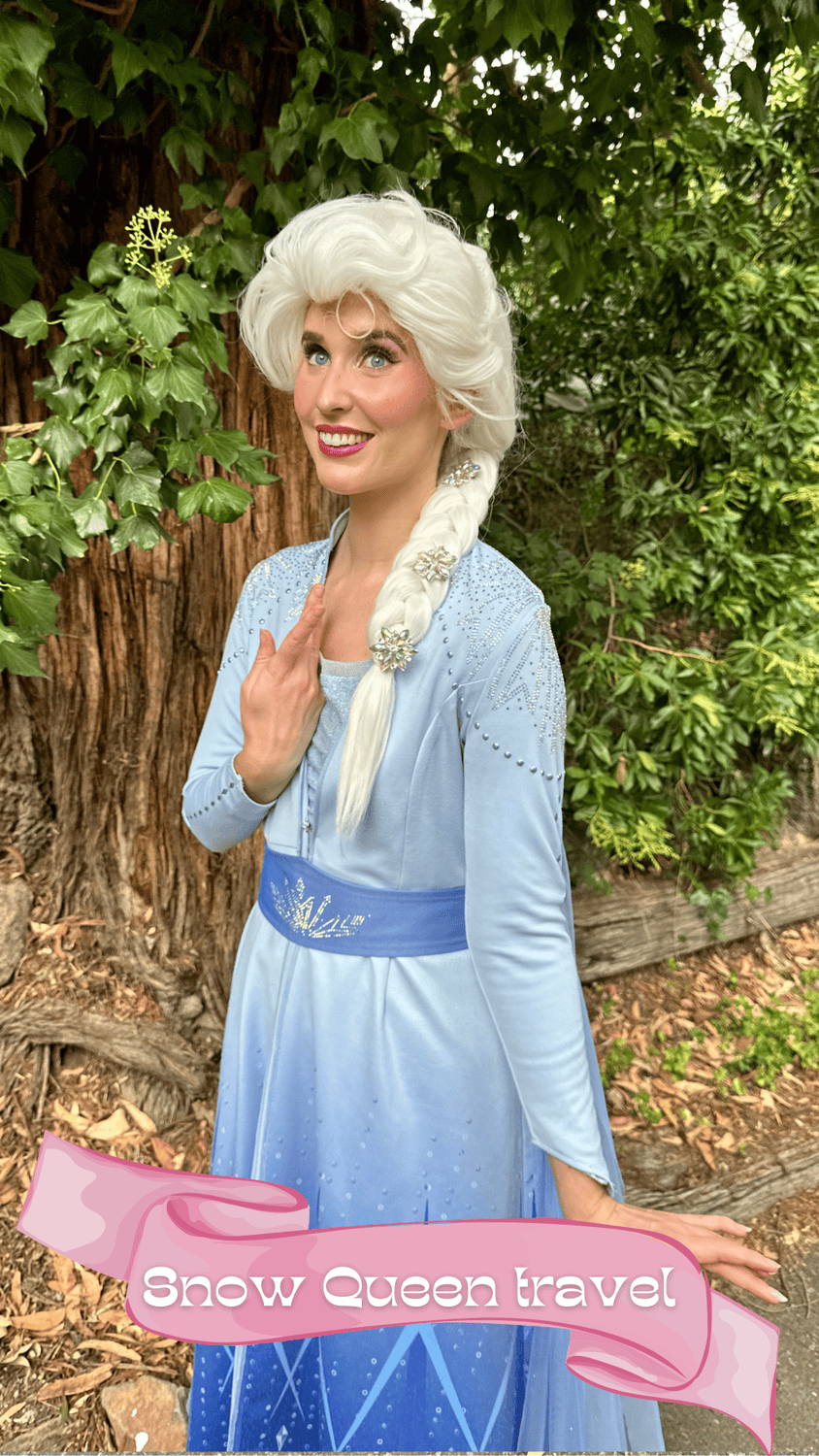 A woman dressed as a snow queen with white hair, a blue dress with embellishments, and decorative flowers in her braid, standing outdoors near a tree with green leaves. The image features a pink banner with the text 'Snow Queen travel' at the bottom.