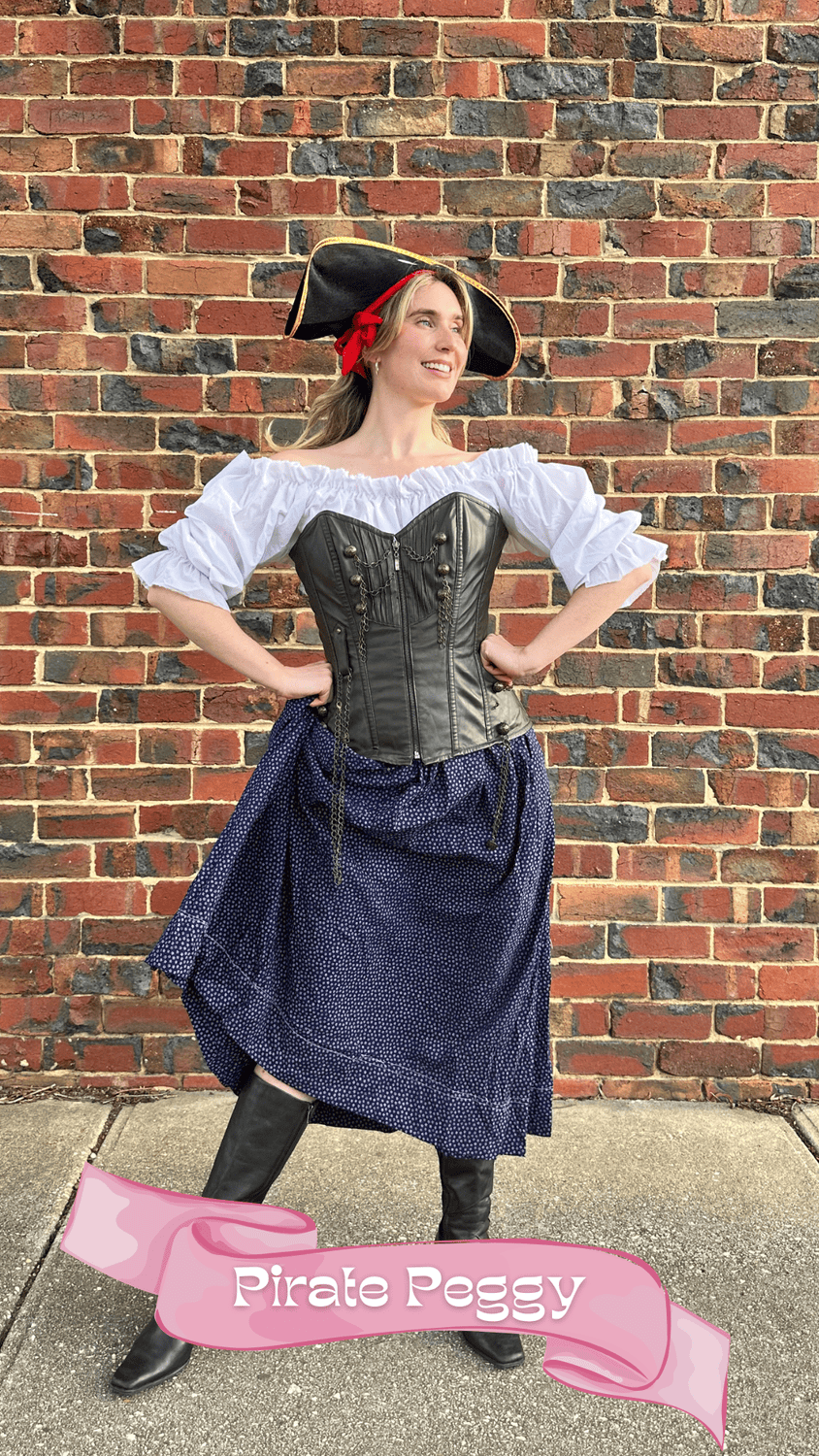 Woman dressed as a pirate standing in front of a brick wall, wearing a tricorn hat, white blouse, black leather corset, navy skirt, and black boots, with a pink banner at the bottom reading 'Pirate Peggy.'