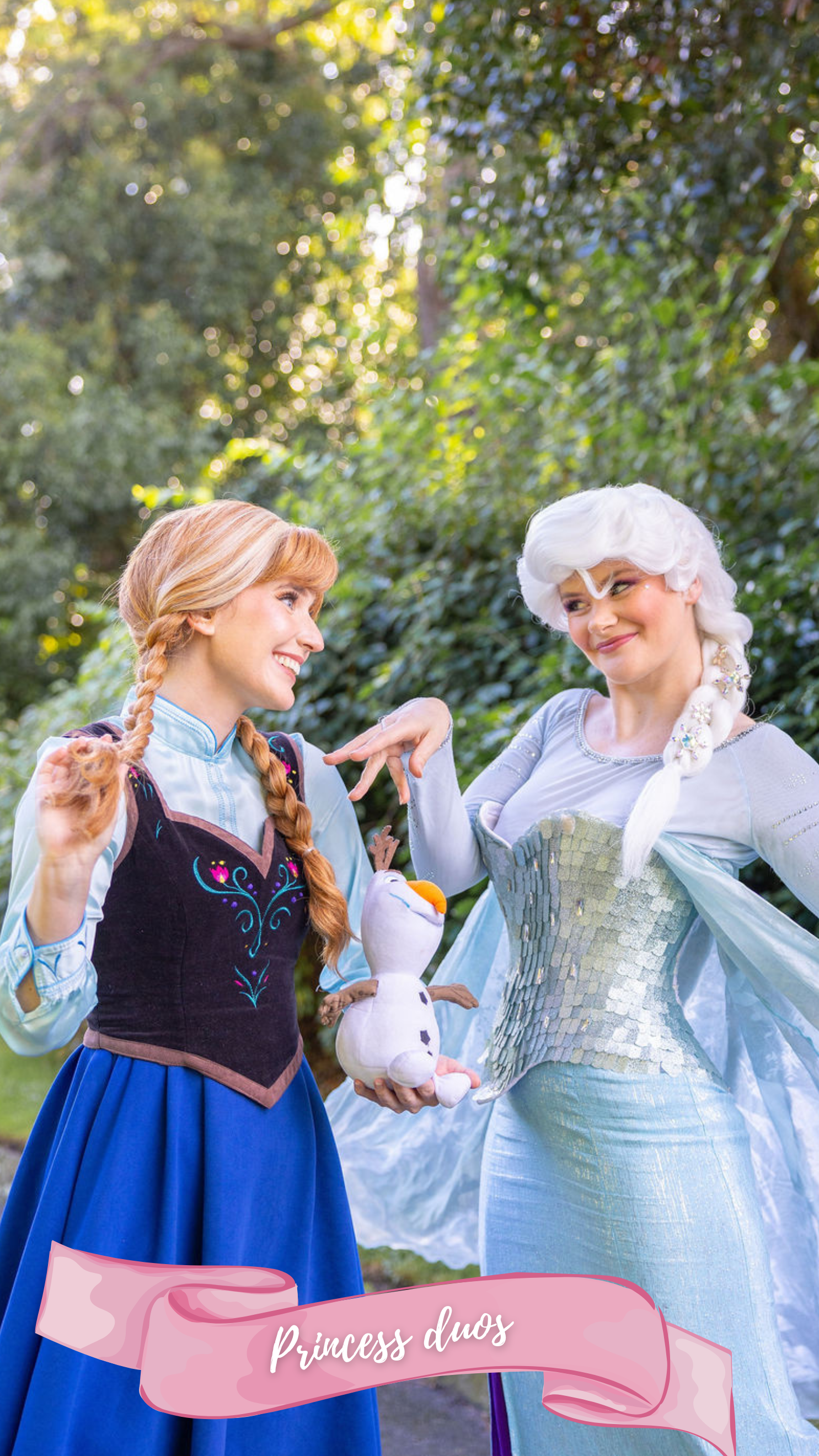 A woman dressed as the princess from the fairy tale Frozen, wearing a blue skirt, blue top, sparkly corset with snowflakes in her white hair, standing outdoors on a path with trees in the background. and a woman dressed as the princess from the fairy