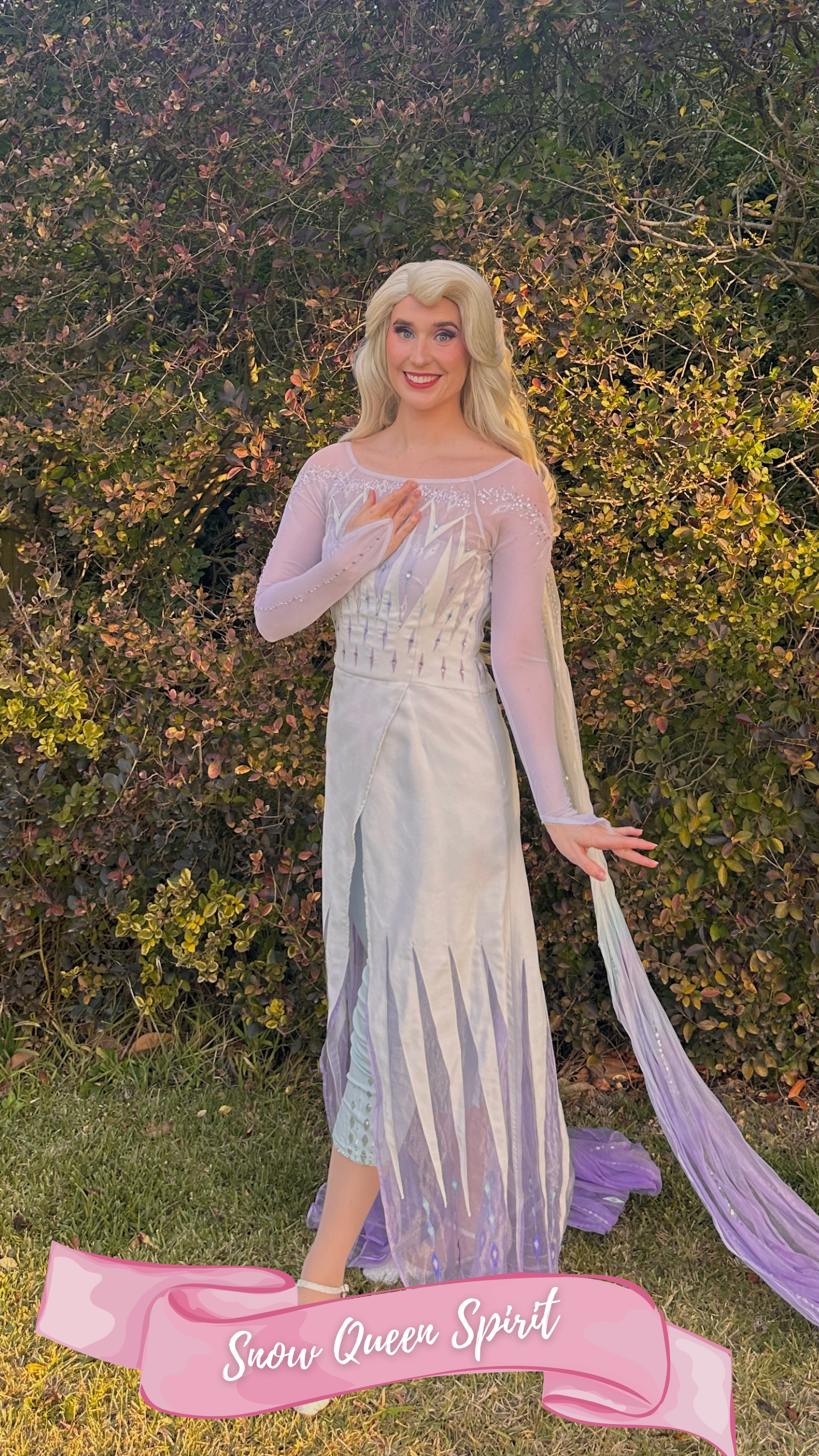 A woman dressed as the princess from the fairy tale Frozen, wearing a white and purple dress , sparkly white shoes with snowflakes in her white hair, standing outdoors on grass with hedges in the background.