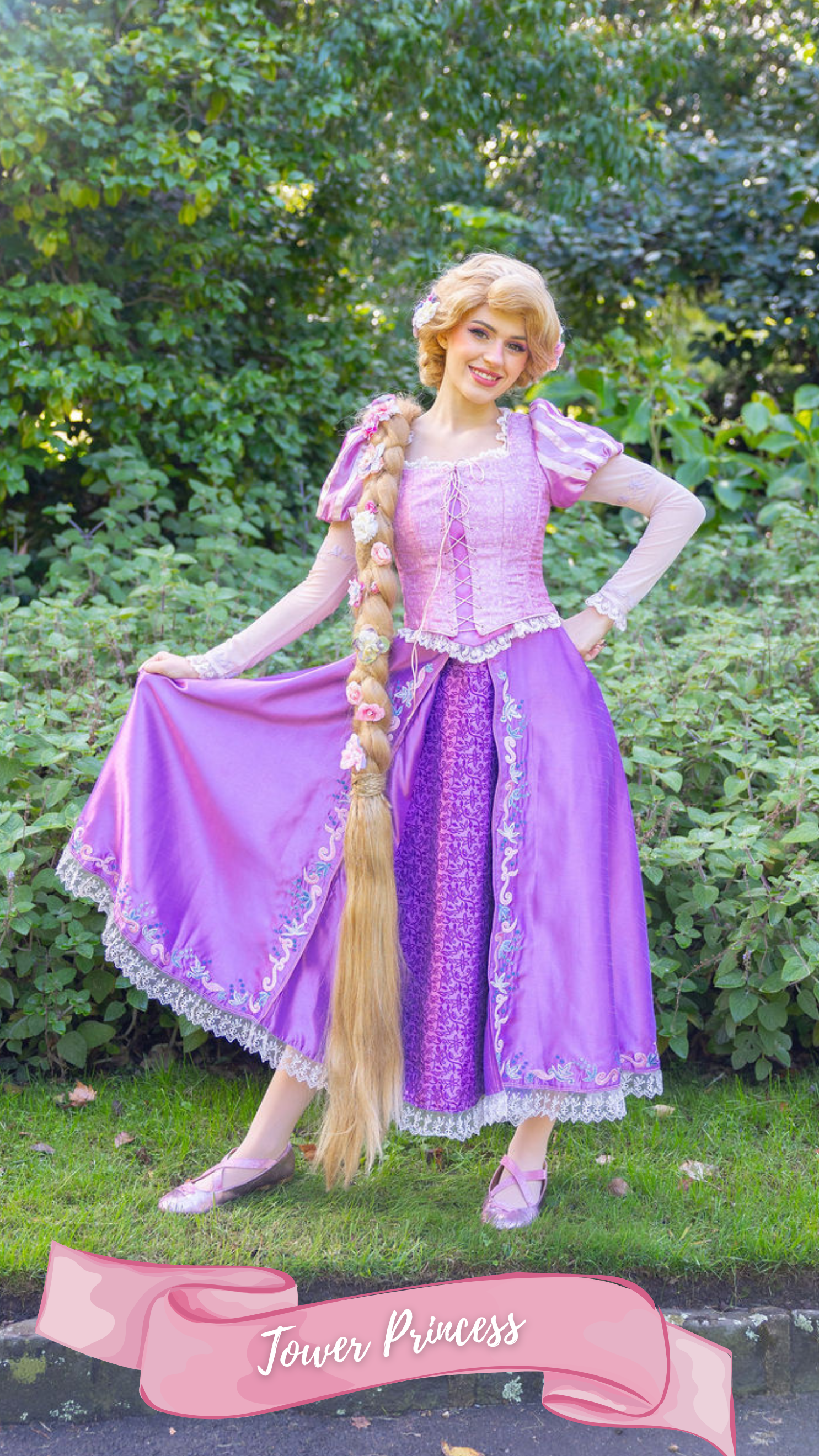 A woman dressed as Rapunzel from Disney's Tangled in a purple and pink gown, standing outdoors in a forested area with trees and sunlight, holding up her dress and smiling.