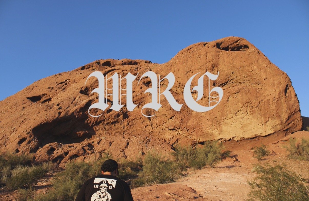 Person walking in front of a large rock formation with the word 'MARS' overlaid on the rock during daytime.
