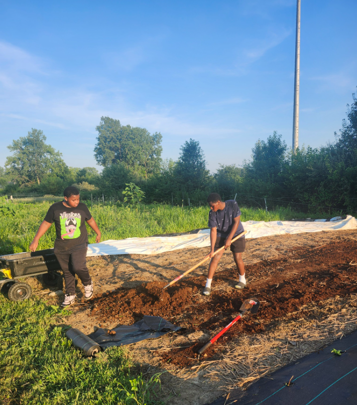 Youth working in a garden bed at Efinity Harvest Farm in Ohio preparing soil and planting, supporting hands on agriculture education, sustainable farming practices, and community food systems