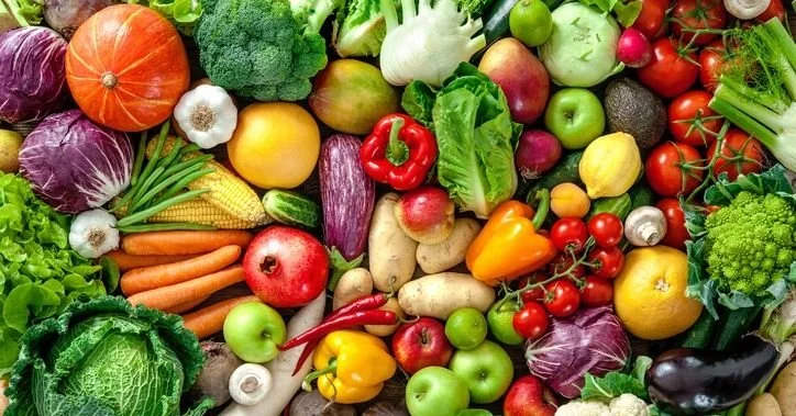 Colorful assortment of fresh fruits and vegetables including tomatoes, carrots, leafy greens, peppers, apples, broccoli, and squash, representing organic produce, healthy eating, local farming, and sustainable agriculture
