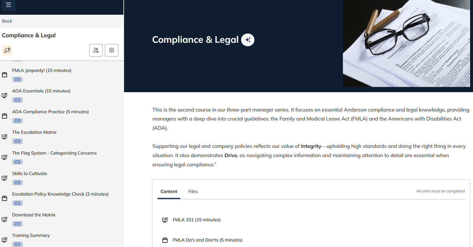 A computer screen displaying a webpage on compliance and legal topics, with a photo of glasses and pens resting on papers with printed text in the upper right corner.