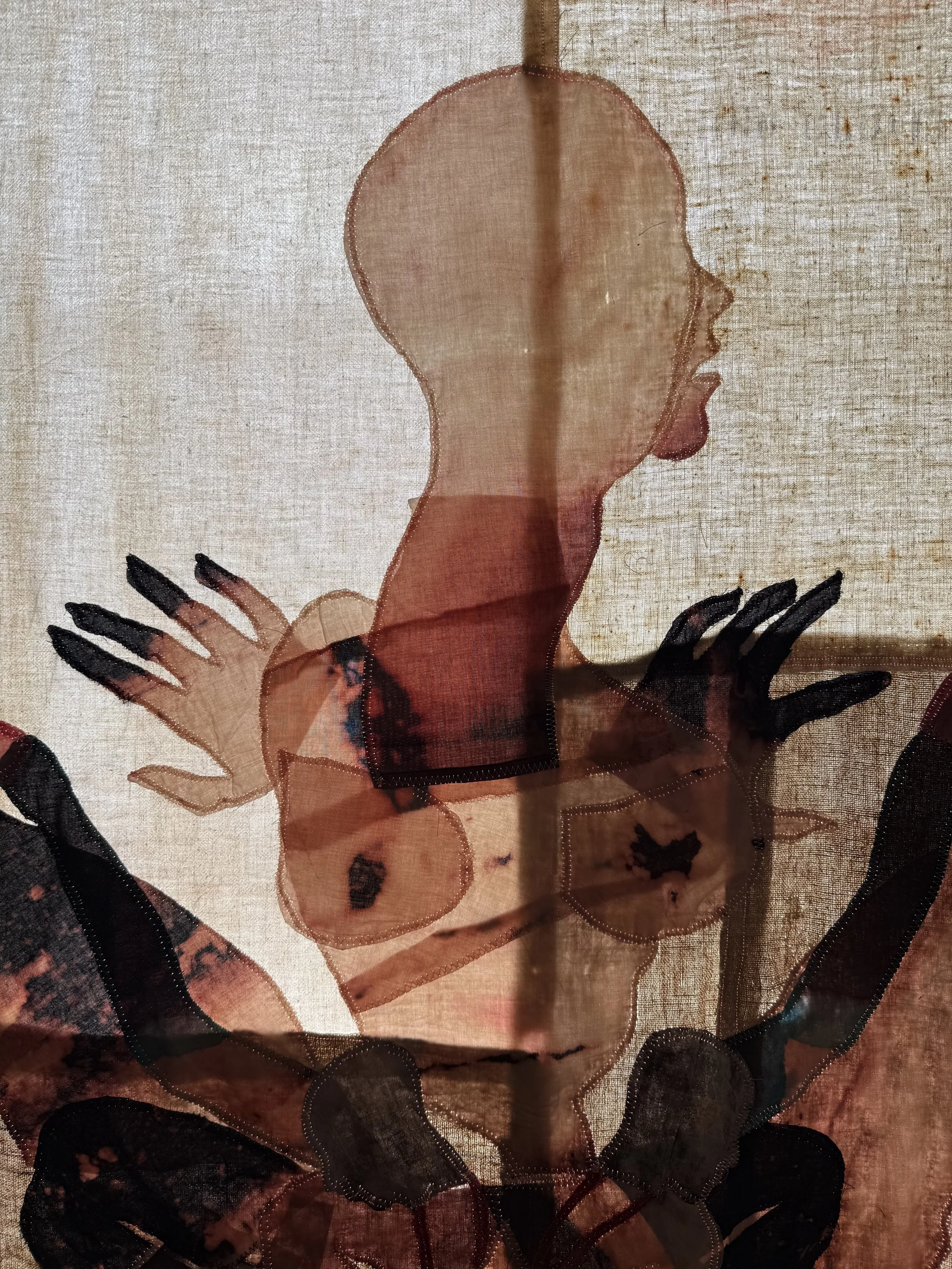 "Cecilia" (2026) (detail, in evening light) 70" x 57" Bleached bedsheets, coffee, fluid watercolor, relief prints, used feed, seed and soap sacks, hand embroidery, 