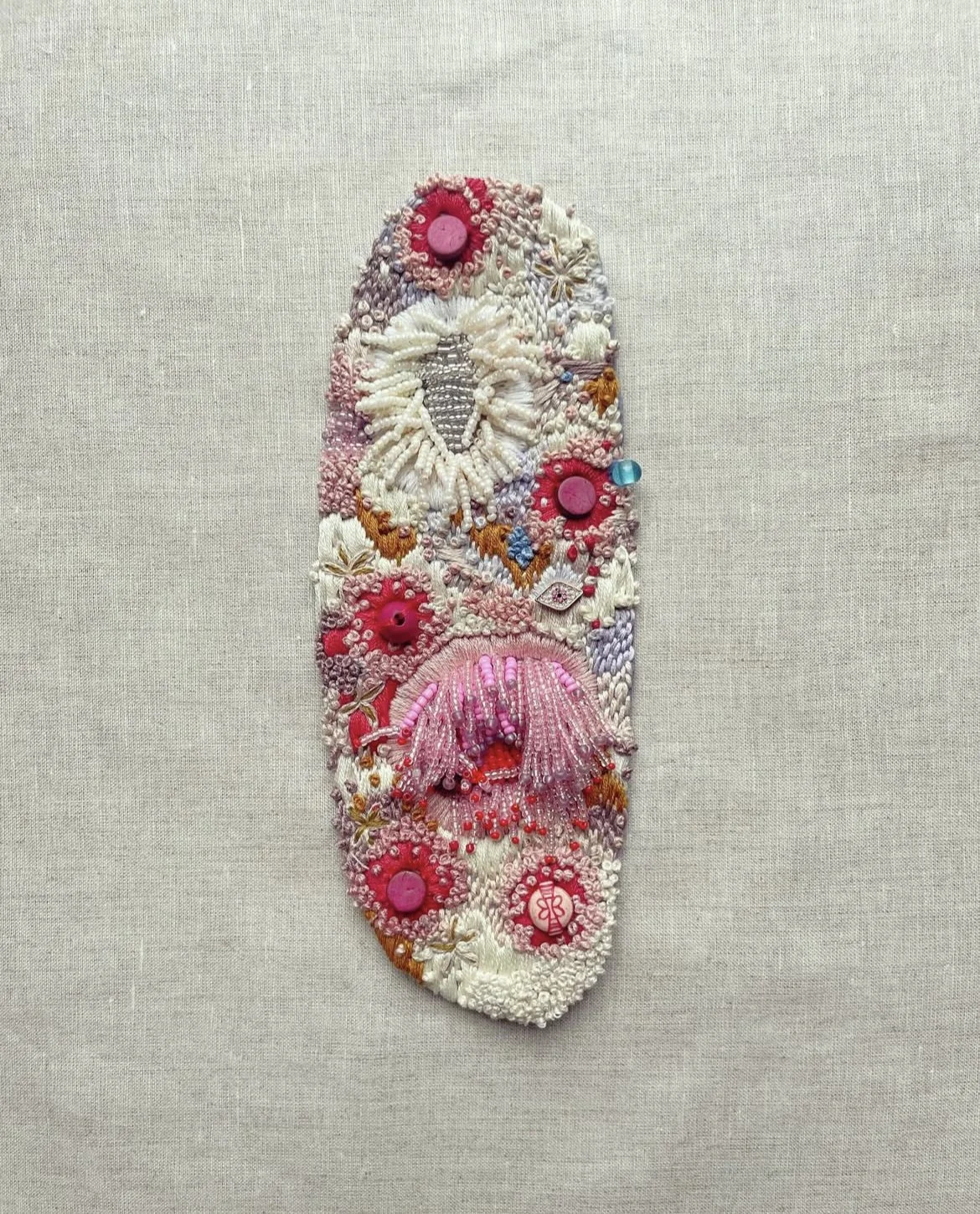 "Love Bug" (2024) 11" x 4" hand embroidery and beading on linen. UNAVAILABLE