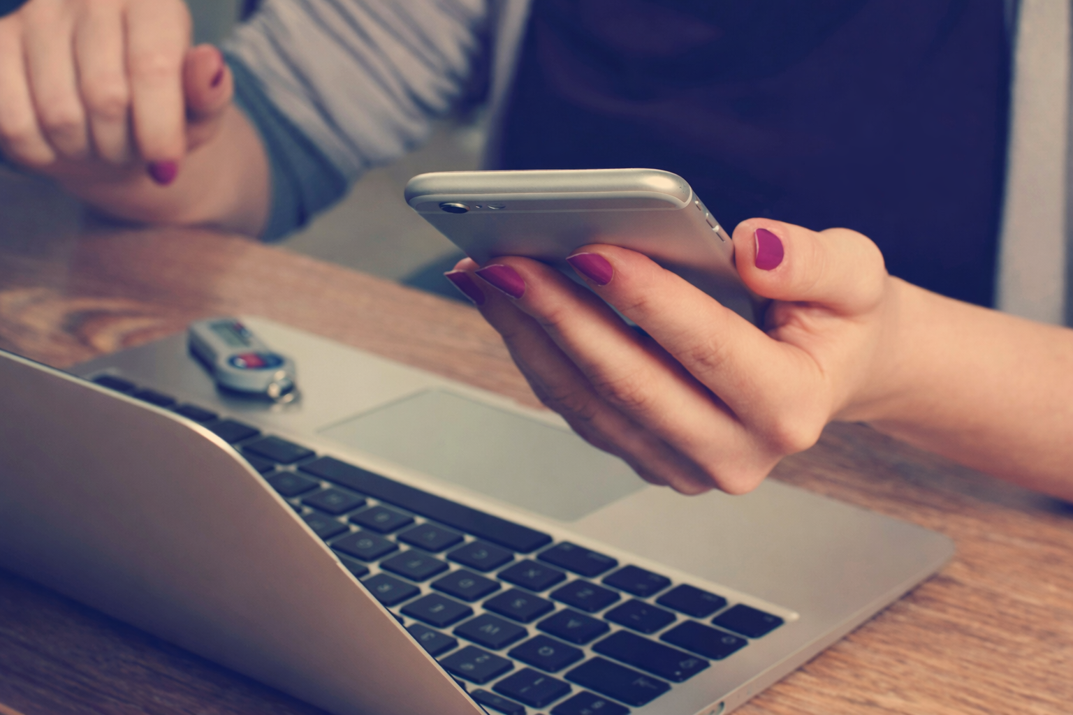 A person holding a smartphone reaching out to connect with BASE Data Advisory for a consultation on data strategy solutions for startup-to-scaleup companies.