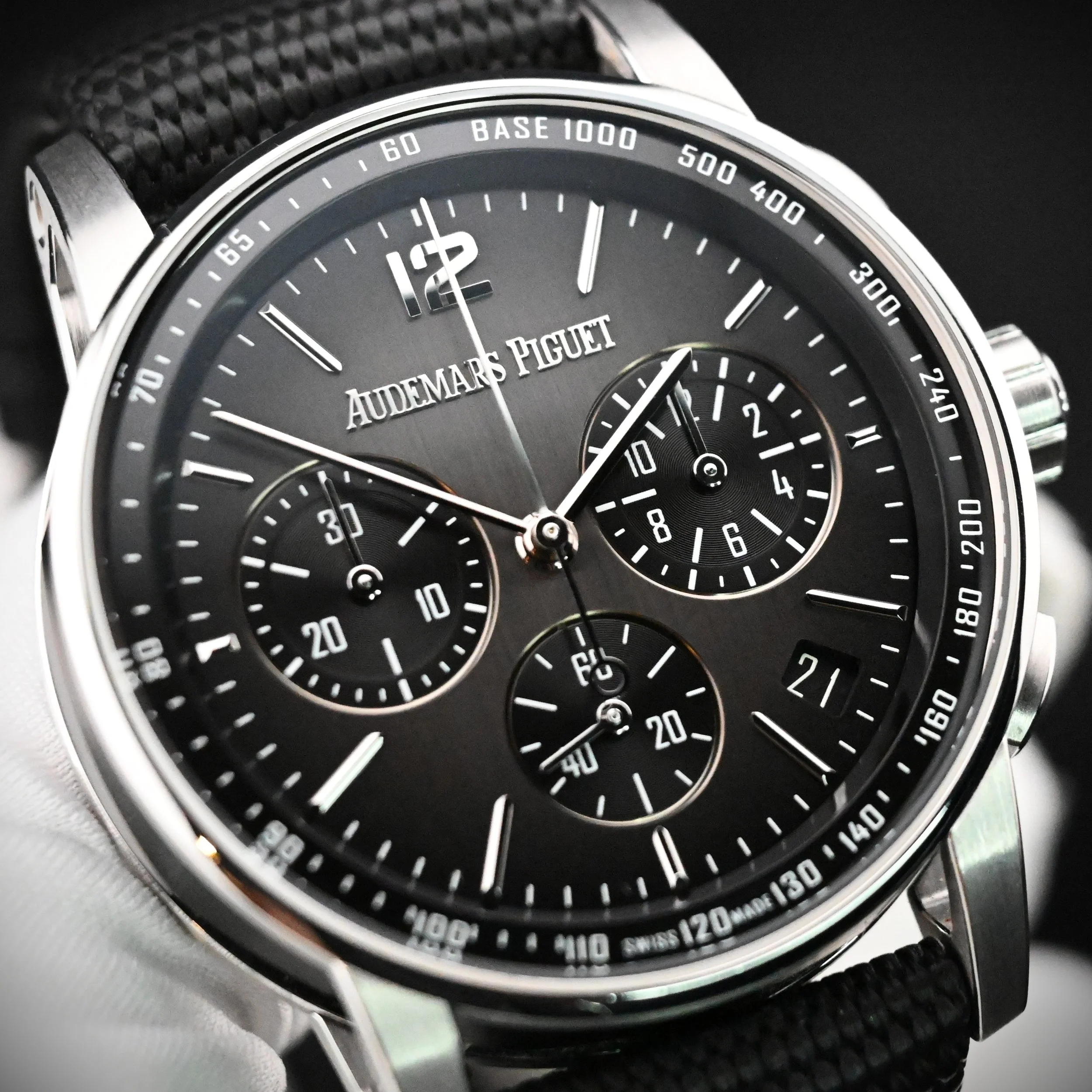 Close-up of an Audemars Piguet luxury wristwatch with a black dial, silver and white accents, multiple subdials, and a chronograph feature.