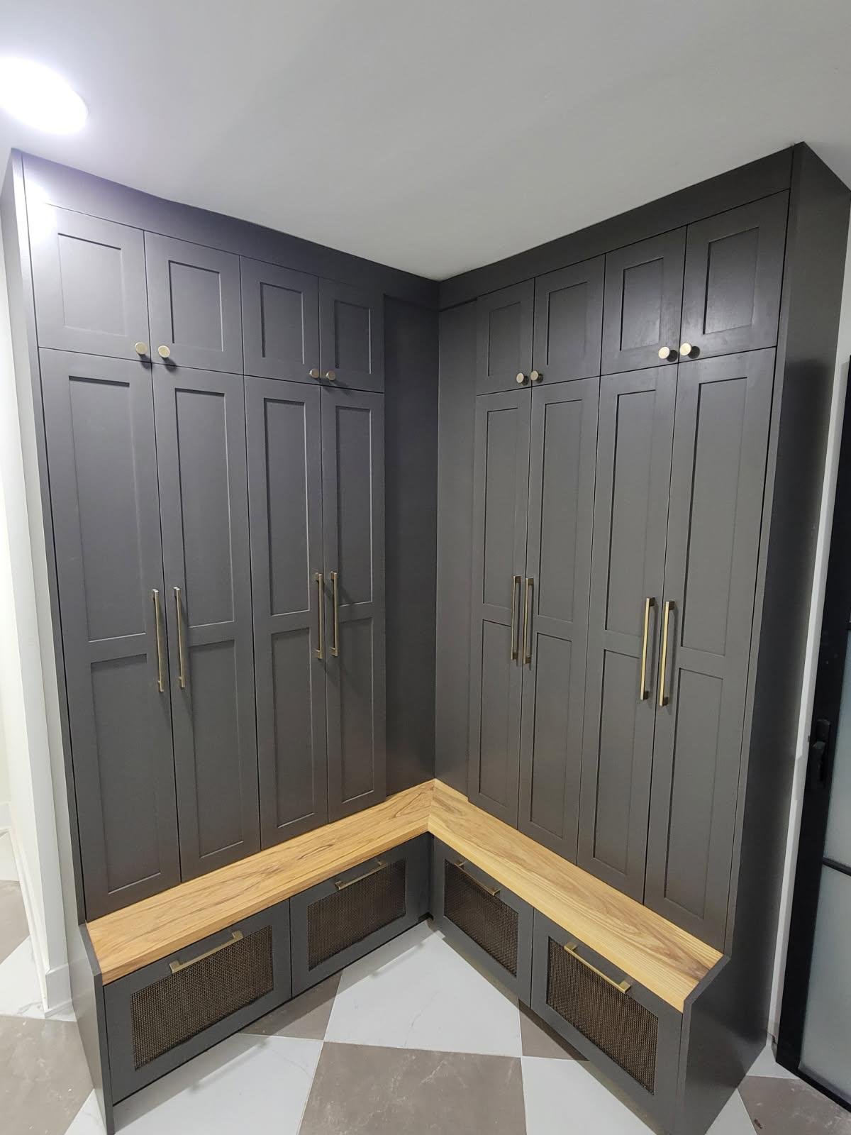 Corner kitchen with gray cabinets, wooden accents, and metallic handles.