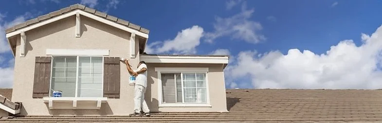 Person cleaning the windows of a house's second story.