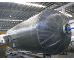 Large metallic industrial tank or pressure vessel inside a factory or warehouse.