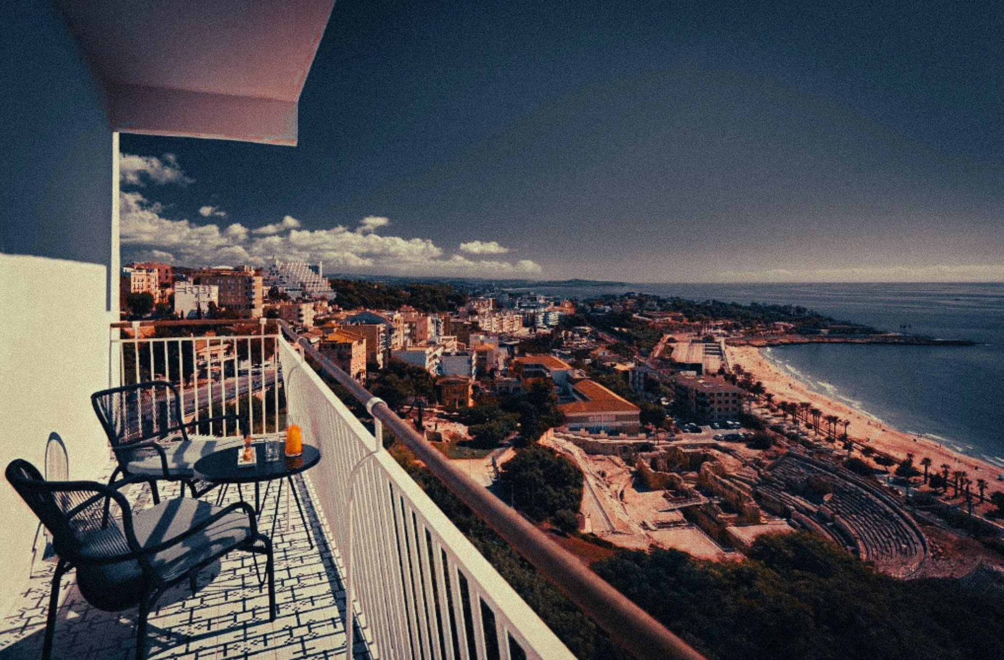 Beachfront hotel view over Tarragona with the Roman amphitheatre and sea below.