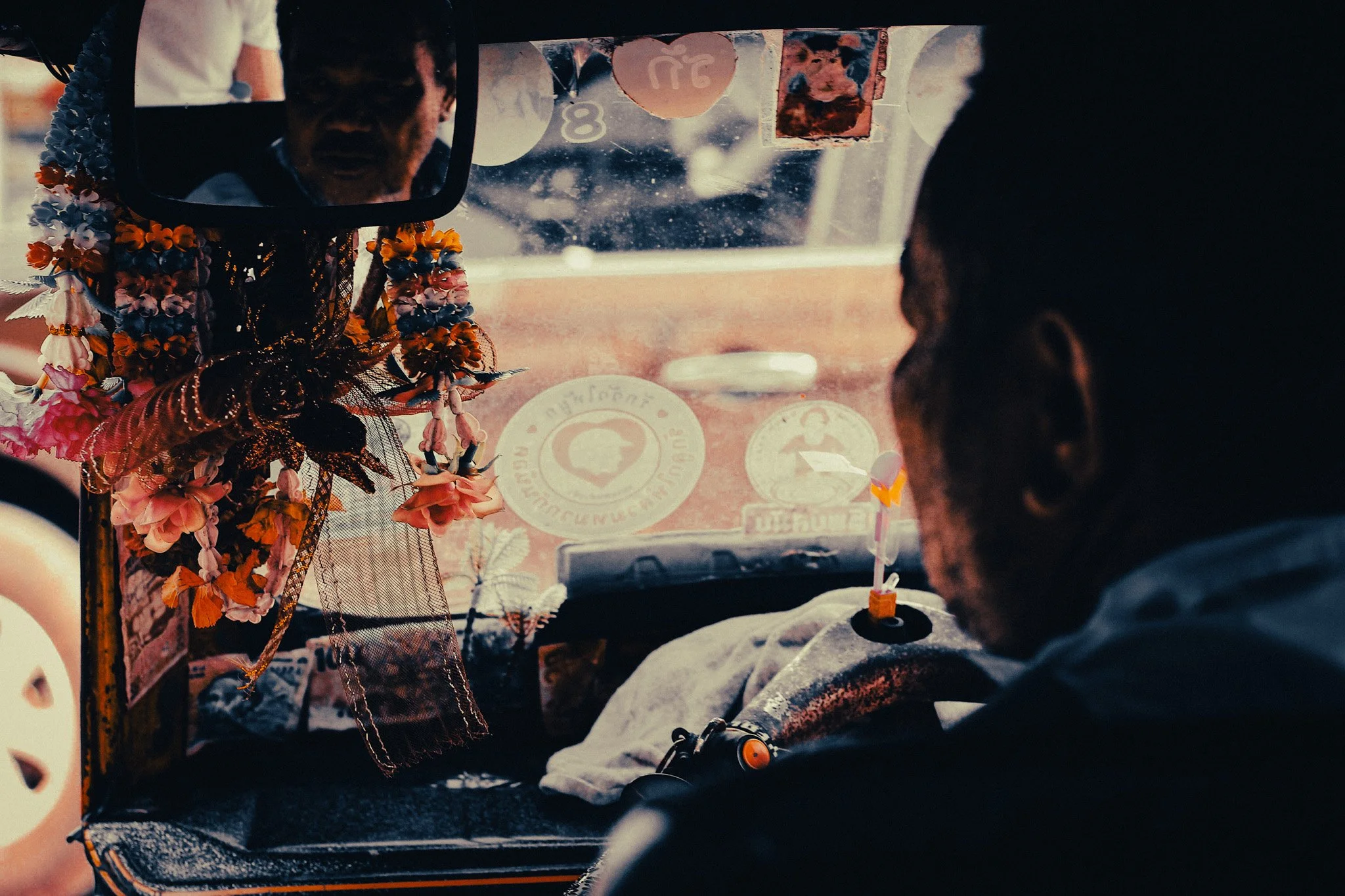 Inside a Phuket taxi with flower garlands hanging from the mirror during a southern Thailand itinerary.