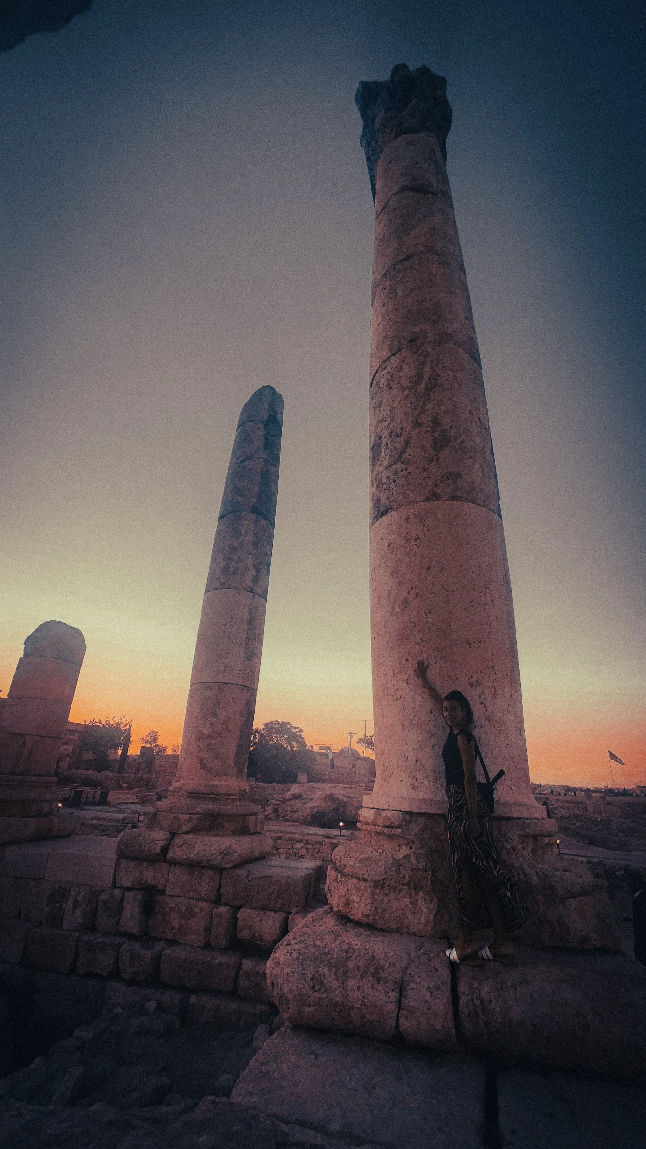 woman standing by a roman column in the citadel in amman jordan