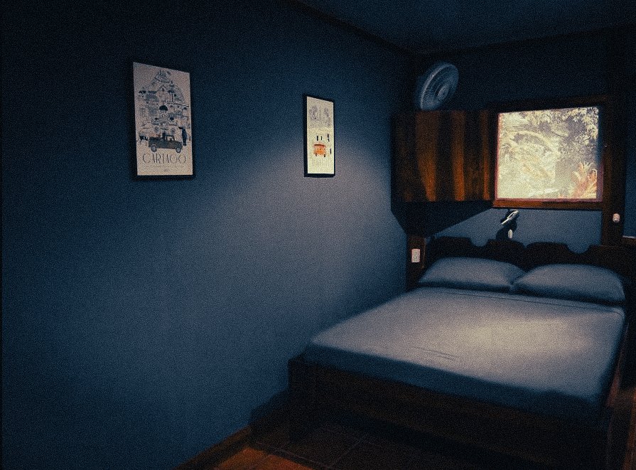 Simple private room at Casa Moabi in Playa Chiquita, Costa Rica, with a double bed, dark blue walls and jungle views from the window near Puerto Viejo.