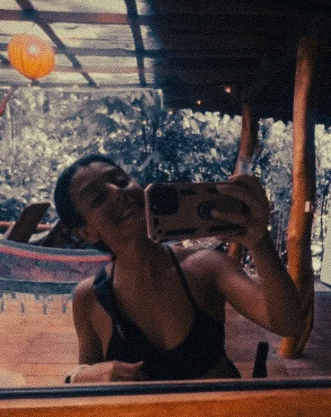 Guest taking a mirror selfie at Casa Moabi in Playa Chiquita, Costa Rica, with hammocks and jungle greenery in the background near Puerto Viejo.