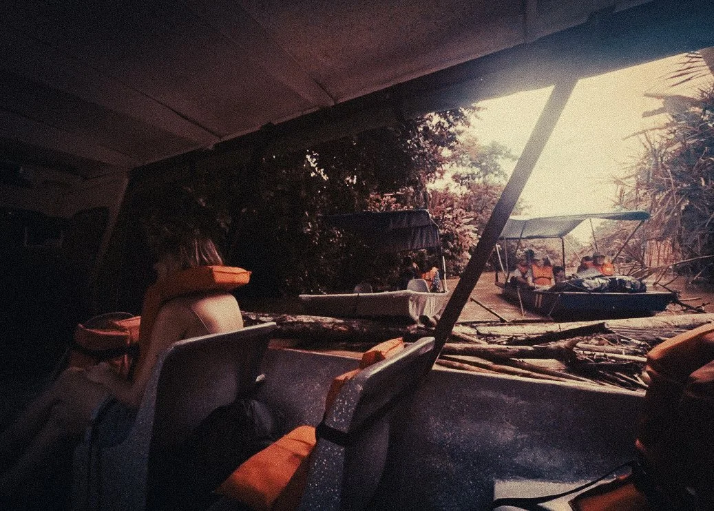Passengers waiting inside a boat on Costa Rica’s Caribbean canals near Parismina, with jungle trees and a small dock area outside before travelling toward Moín and Puerto Viejo.