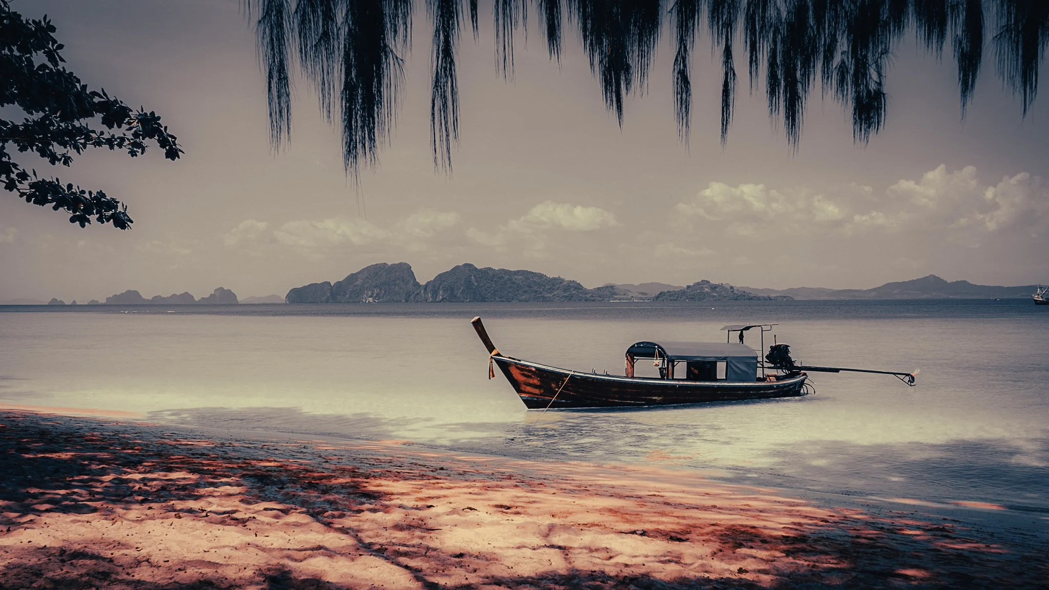 Traditional longtail boat on a quiet beach in the Koh Yao Islands near Phuket, Thailand.
