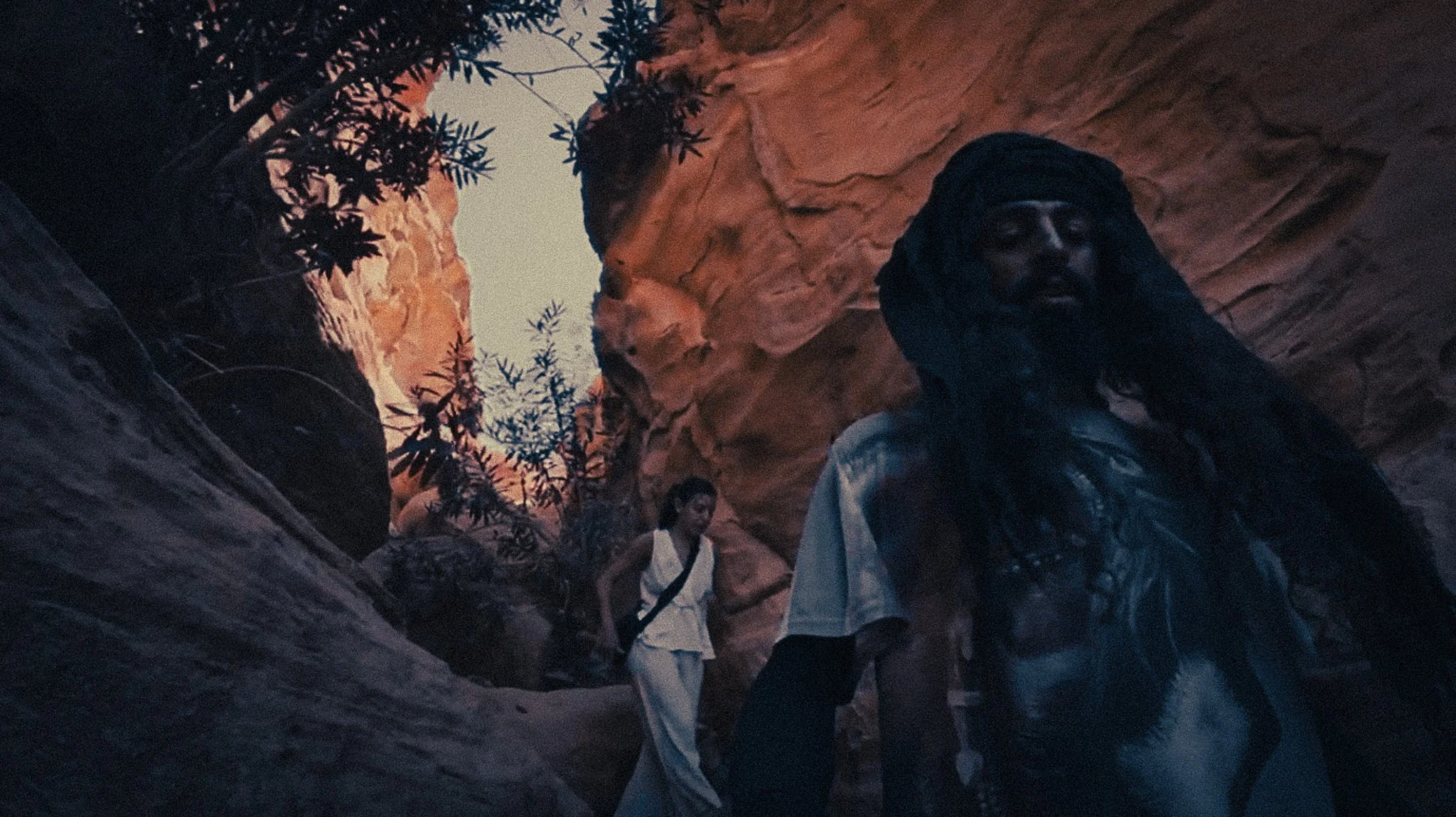 Local guide leading a solo female traveller through a narrow sandstone passage in Petra, Jordan.