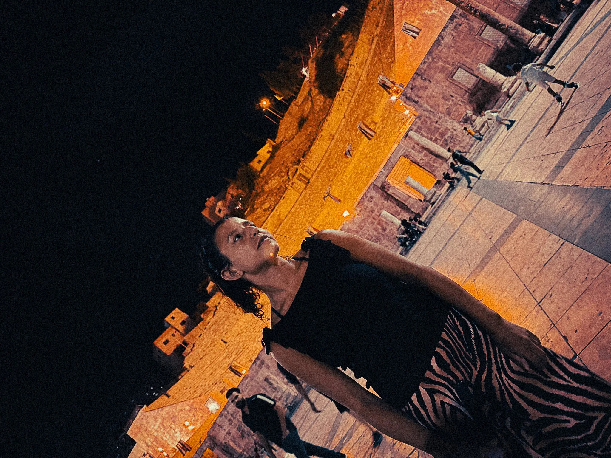 woman standing in the roman theatre in amman downtown at night, in jordan