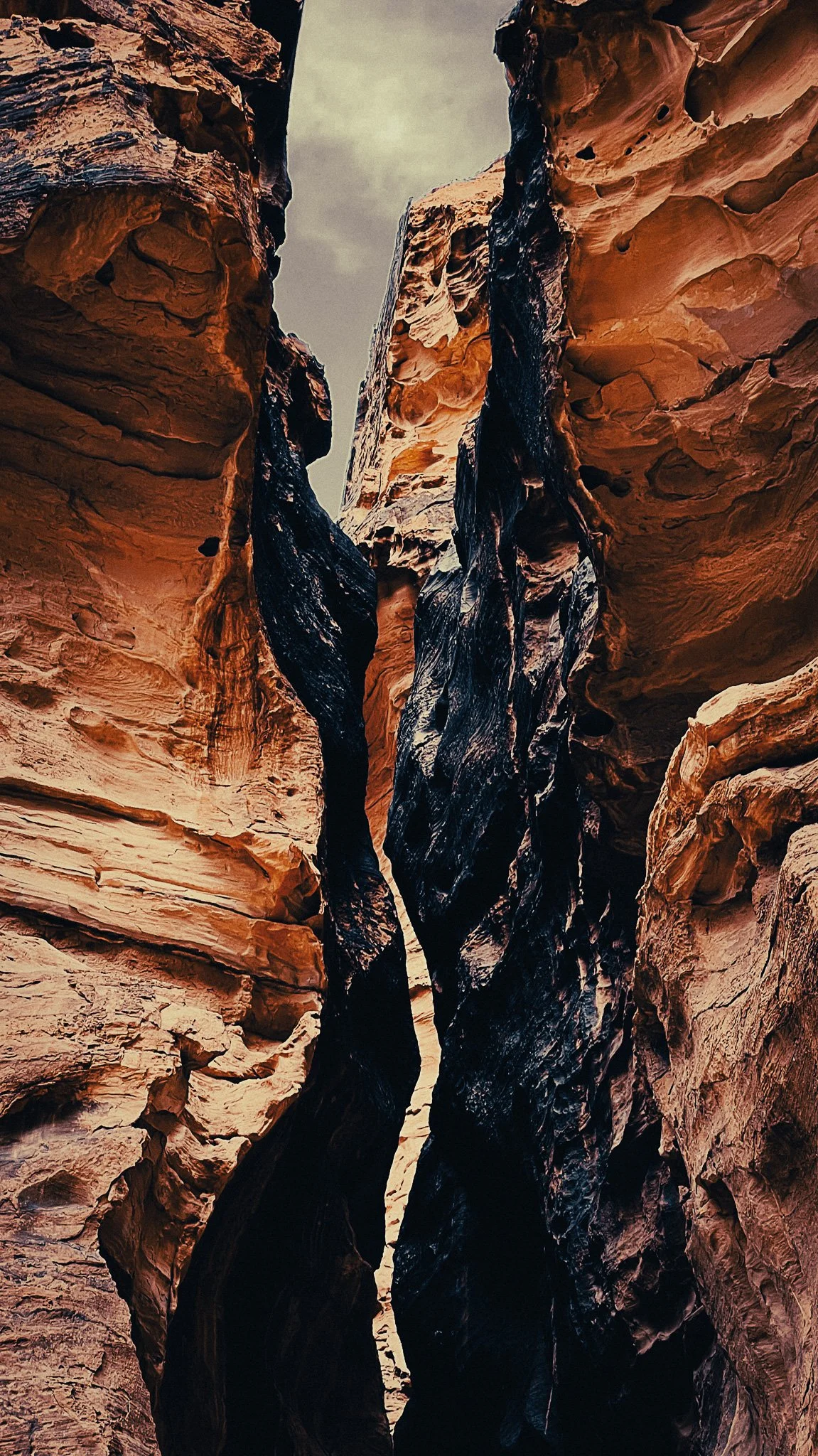 Tall narrow sandstone walls rising above the Wadi Mujib Siq Trail in Jordan.