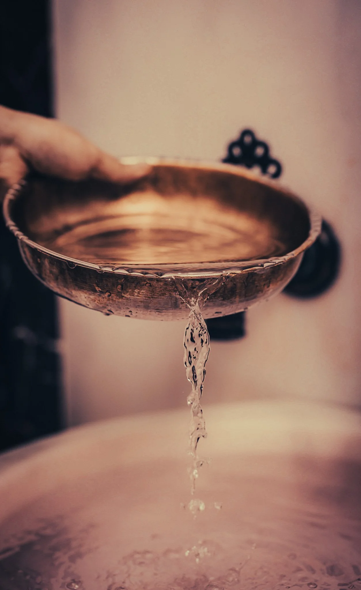 Water pouring down of a golden bowl in a hammam in amman jordan