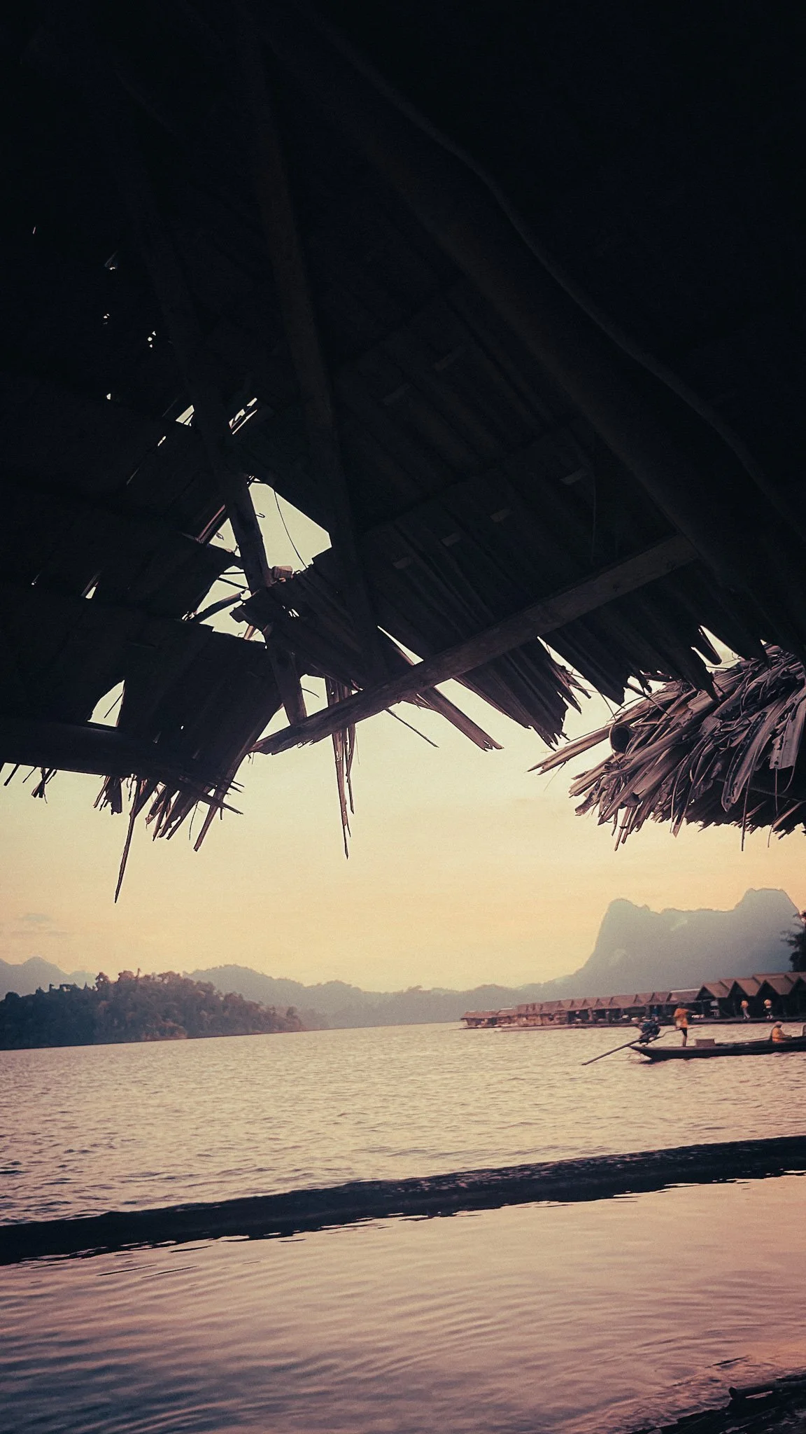 Floating bungalows and longtail boat on Cheow Lan Lake in Khao Sok National Park, Thailand.