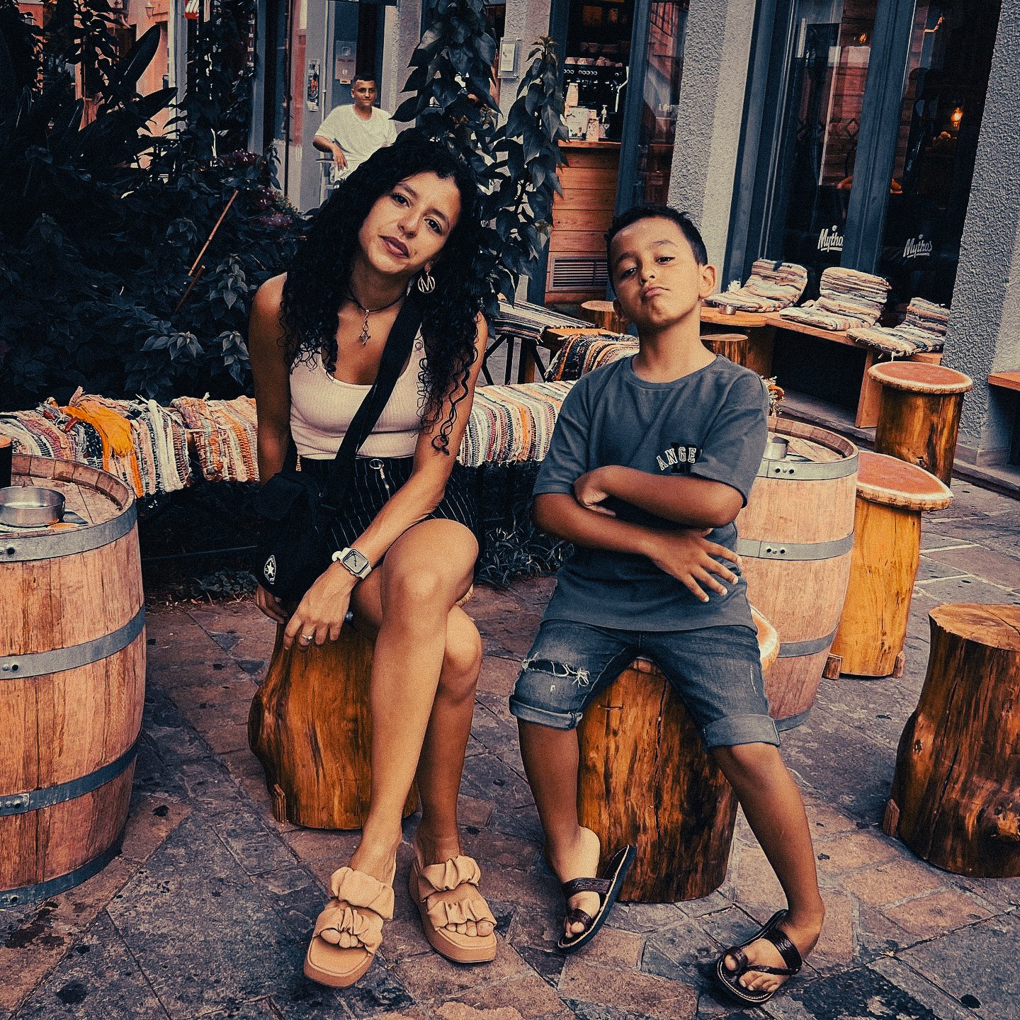 Mother and son sitting outside in Preveza Greece during a relaxed summer evening in town.
