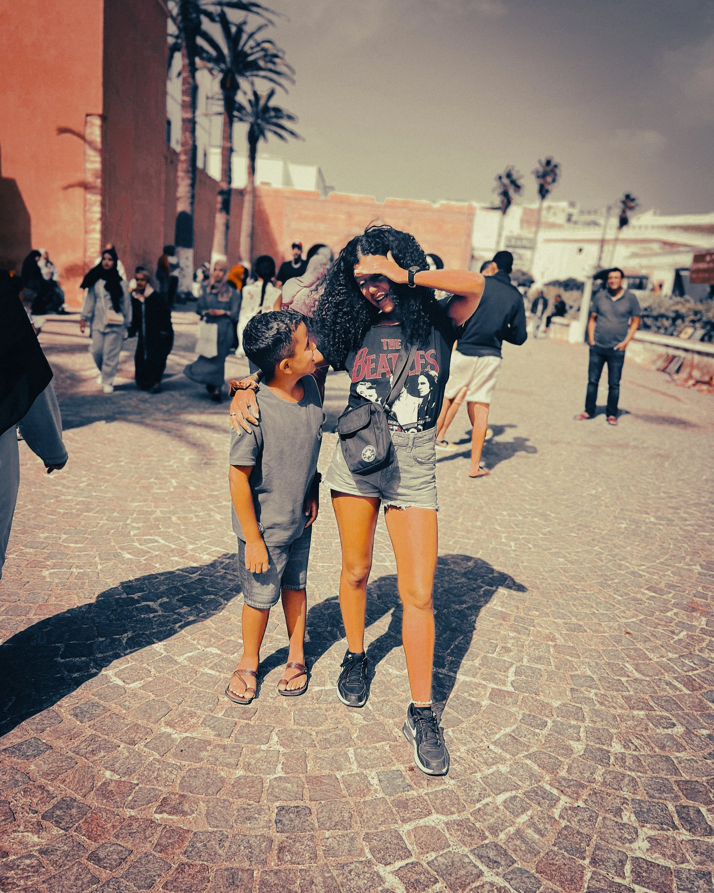 Moroccan woman standing with her young son outside the old medina walls in Essaouira, Morocco, on a sunny summer day during a trip from Marrakech.