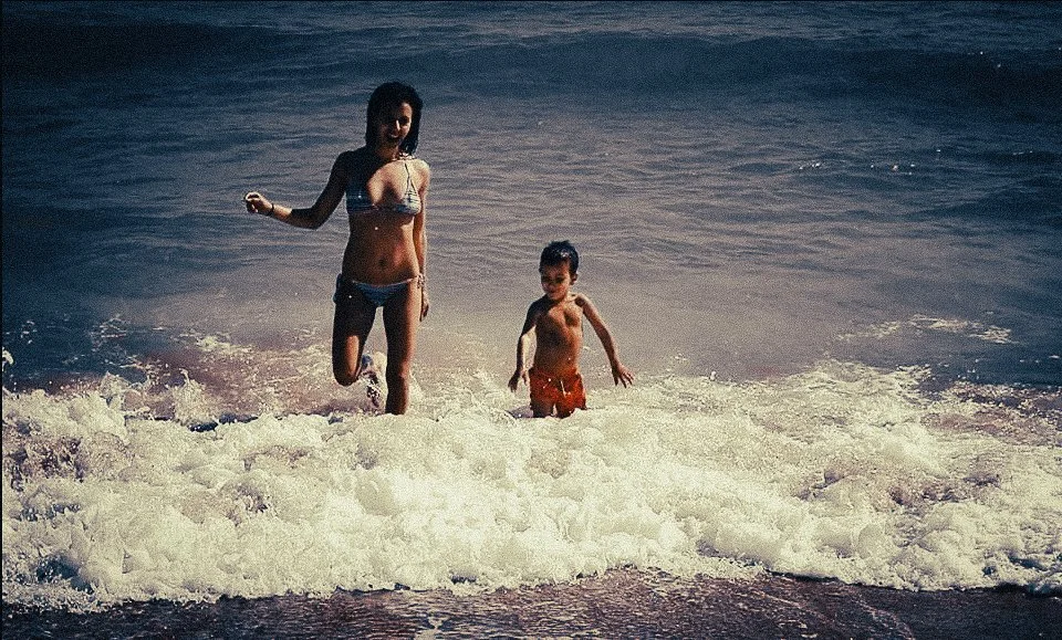 Mother and child playing in the sea during a Sitges Spain beach day trip from Barcelona.