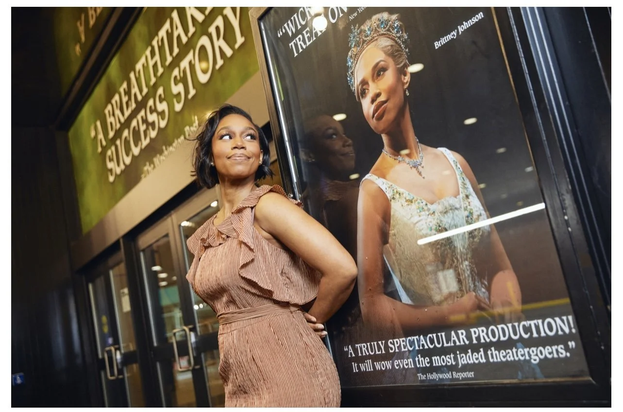 Brittney Johnson beside her Wicked poster