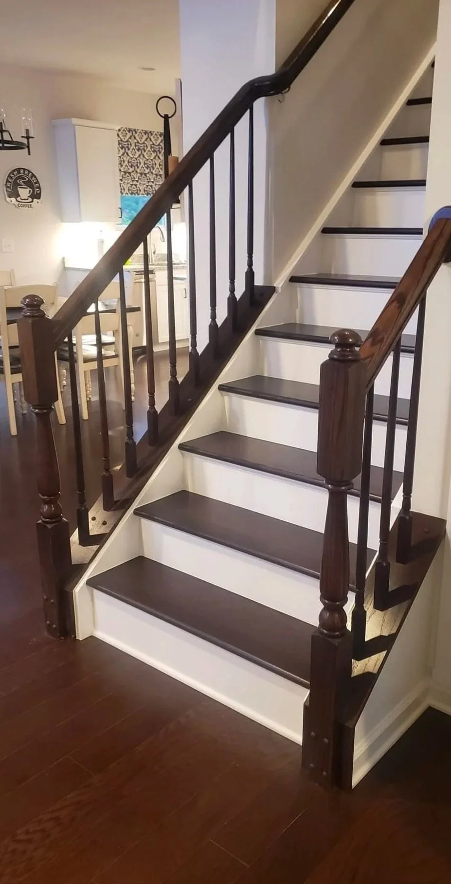 Wooden staircase with dark treads and light risers leading to the upper floor in a home interior.