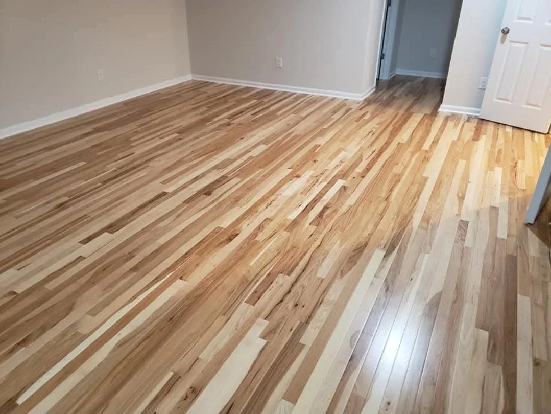 Empty room with hardwood floors being installed or refinished.