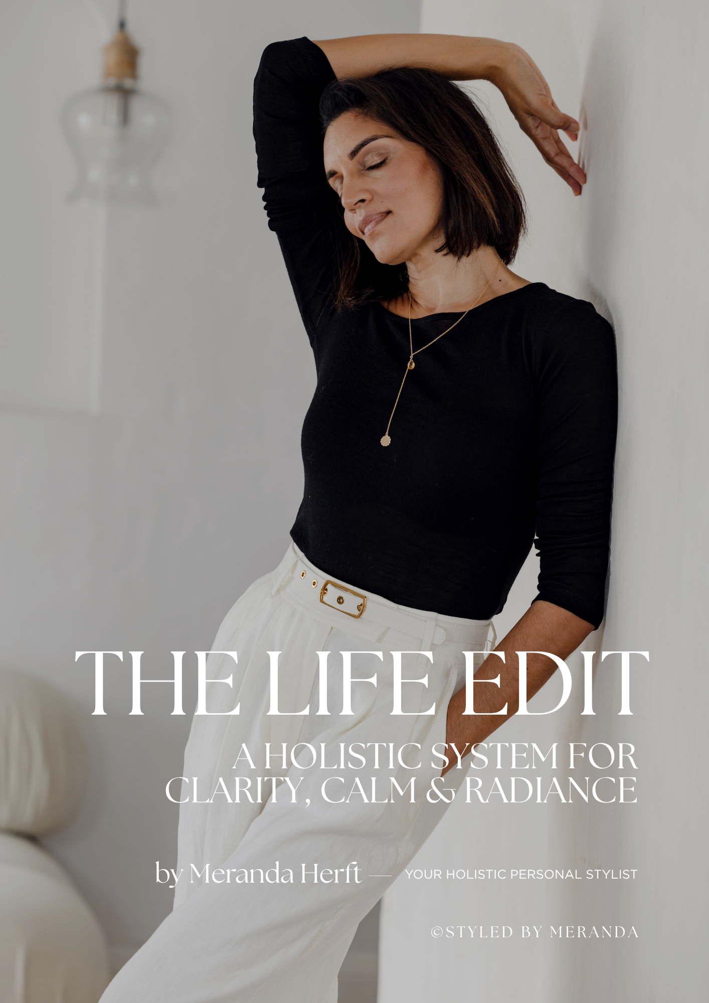 Cover image of a book titled "The Life Edit: A Holistic System for Clarity, Calm & Radiance" by Meranda Herft, featuring a woman with dark hair, wearing a black top, smiling with eyes closed, leaning against a white wall.