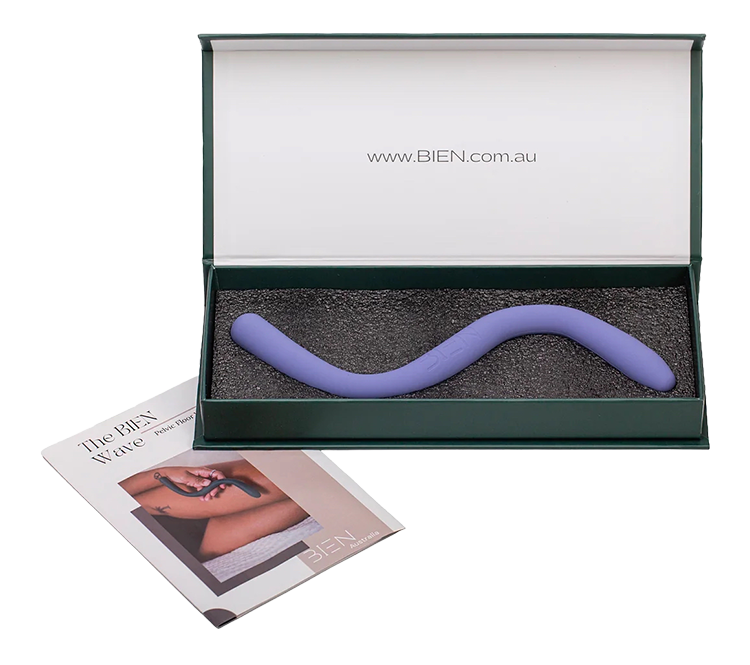 A curved purple silicone adult toy inside a black foam-lined box with an inner lid displaying the website URL 'www.BIEN.com.au'. A folded promotional brochure featuring a person holding a similar toy is placed beside the box.