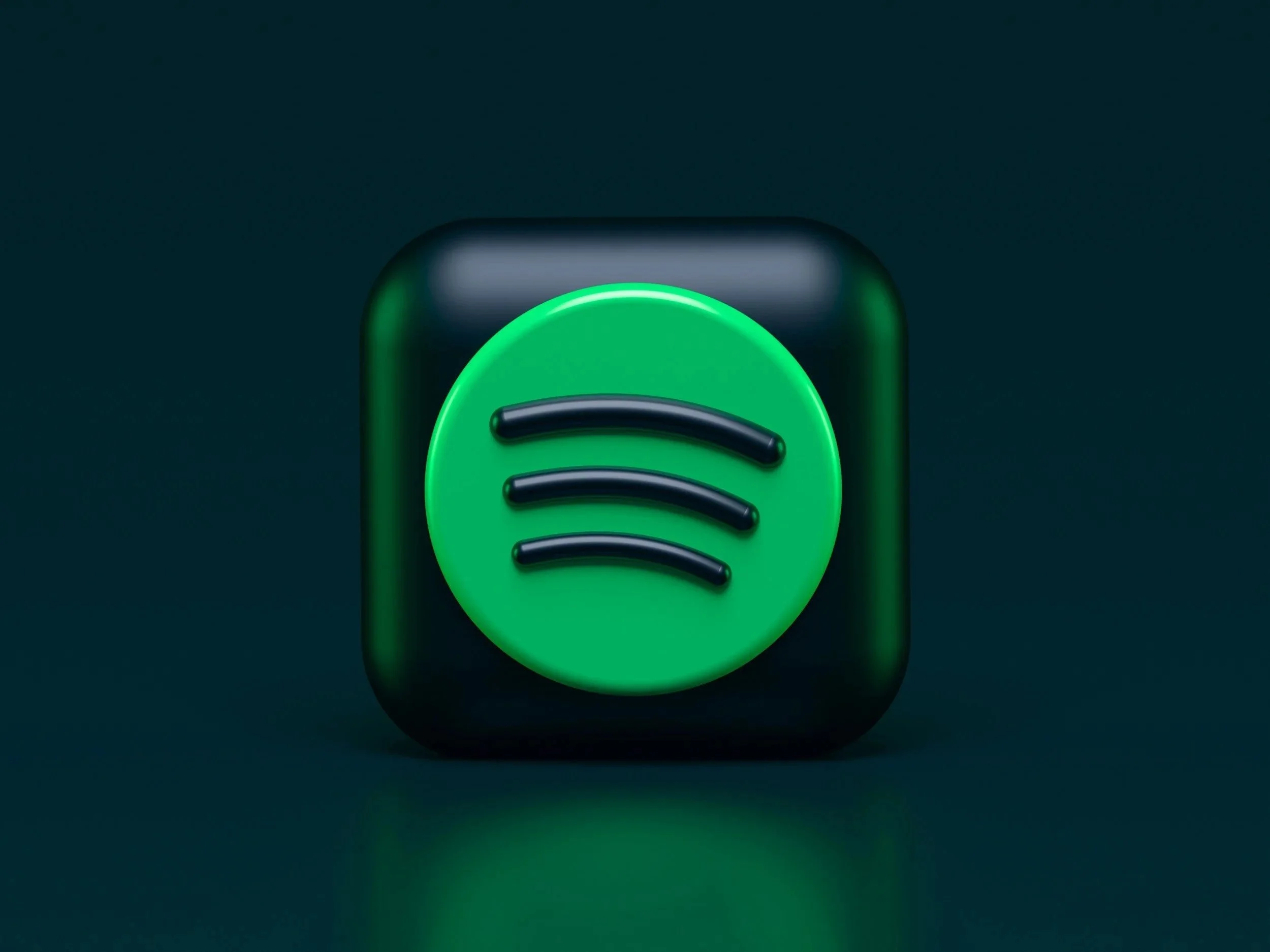 Close-up of a black and green Spotify app icon with a circular green background and three black curved lines in the center.